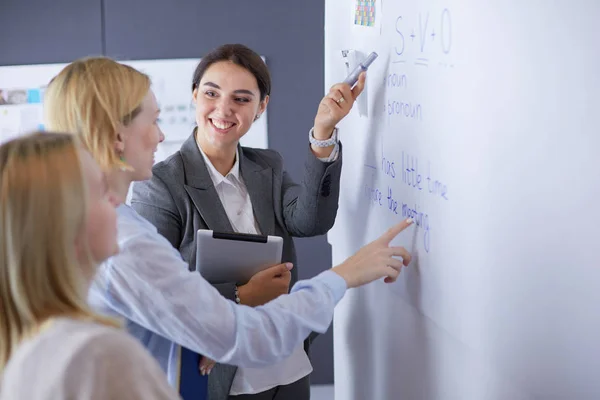 Concepto de negocio, educación y oficina - equipo de negocios con flip board en la oficina discutiendo algo. —  Fotos de Stock