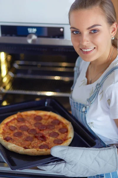 Glückliche junge Frau kocht zu Hause Pizza — Stockfoto