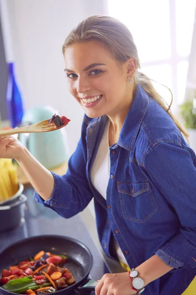 Mujer joven cocinando alimentos saludables sosteniendo una sartén con verduras es. Estilo de vida saludable, cocina en casa concepto —  Fotos de Stock