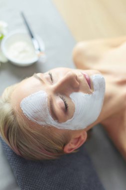 Yüz maskesi. Güzel genç kız Spa, makyajcısı kadın yüz maskesi uygulama.