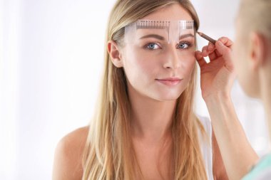 Kaşlar için kalıcı makyaj. Güzellik salonunda kalın kaşlı güzel bir kadın.