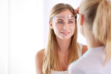 Kaşlar için kalıcı makyaj. Güzellik salonunda kalın kaşlı güzel bir kadın..