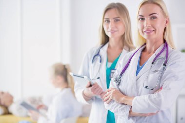tıbbi ofiste geçti silah ile duran üç kendine güvenen kadın doktor portresi.