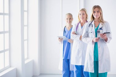 tıbbi ofiste geçti silah ile duran üç kendine güvenen kadın doktor portresi.