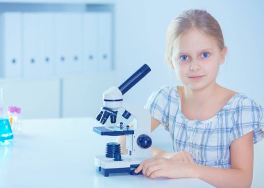 kız öğrenci fen bilgisi dersinde mikroskop aramak.