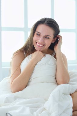 Güzel bir kadın yatağında uzanıyor..