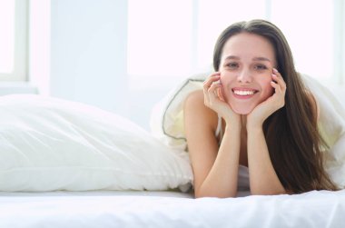 Güzel bir kadın yatağında uzanıyor..