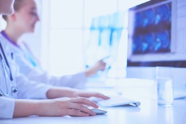 Hastanede bilgisayarla çalışan iki genç bayan doktor..