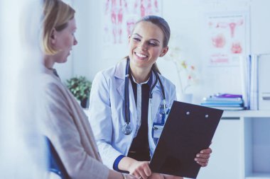 Doktor ve hasta masada otururken bir şey tartışıyorlar. İlaç ve sağlık hizmetleri kavramı