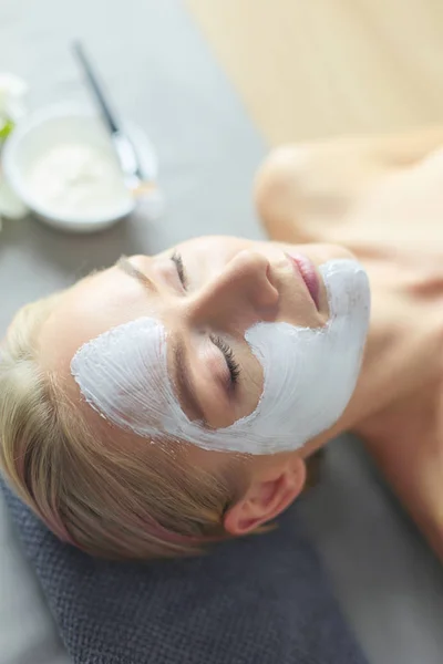 Mascarilla facial. Hermosa joven en el spa, mujer cosmética aplicando mascarilla facial . —  Fotos de Stock