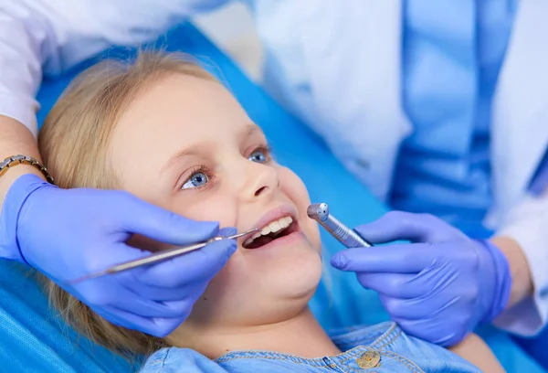 Niña sentada en el consultorio de dentistas. — Foto de Stock