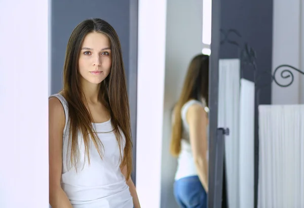 Mujer joven mirándose a sí misma reflejo en el espejo en casa . —  Fotos de Stock