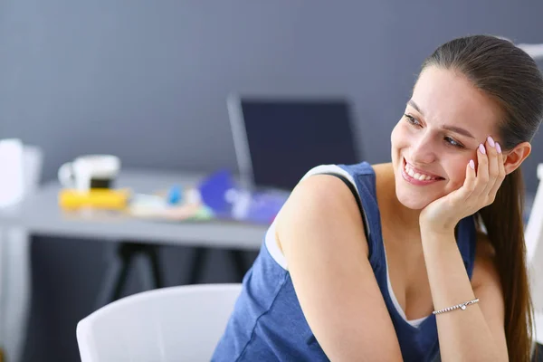 Giovane donna seduta alla scrivania con strumenti, piano e laptop. — Foto Stock