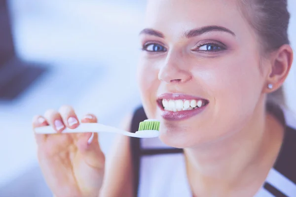 Joven chica bonita manteniendo la higiene bucal con cepillo de dientes . — Foto de Stock