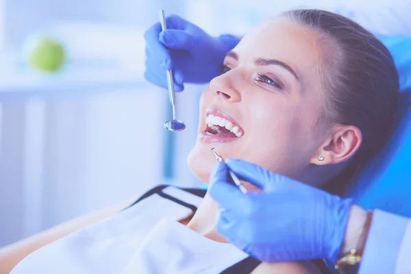 Mujer joven con la boca abierta examinando la inspección dental en el consultorio del dentista. — Foto de Stock