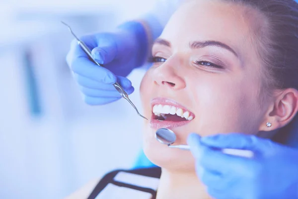 Mujer joven con la boca abierta examinando la inspección dental en el consultorio del dentista. — Foto de Stock