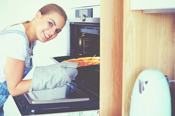 Gelukkig jong vrouw koken pizza thuis — Stockfoto