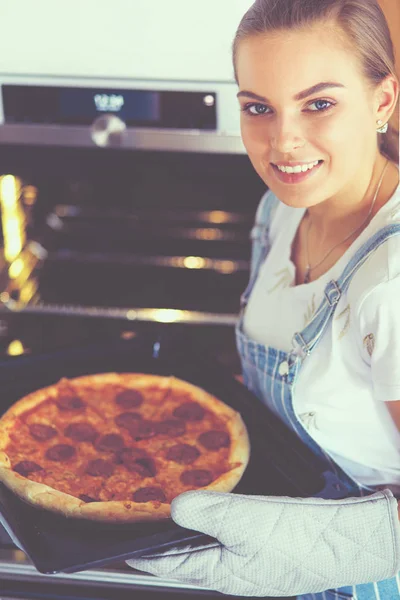 Happy young woman cooking pizza at home — Stock Photo, Image