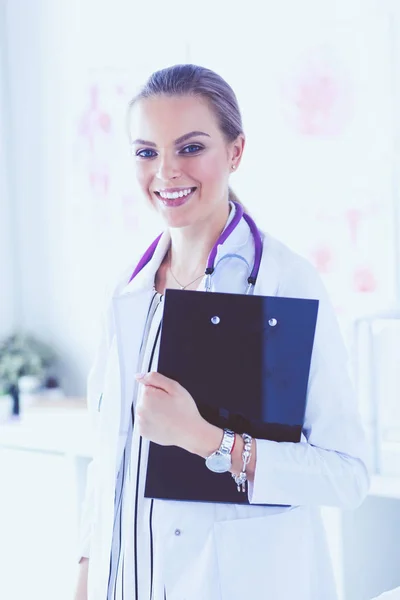 Médico sonriente con una carpeta en uniforme de pie —  Fotos de Stock
