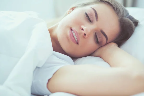 Όμορφη νεαρή ξανθιά γυναίκα στον ύπνο στο κρεβάτι — Φωτογραφία Αρχείου