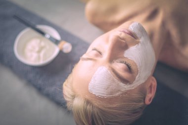 Yüz maskesi. Güzel genç kız Spa, makyajcısı kadın yüz maskesi uygulama.
