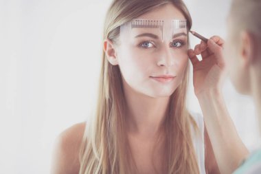 Kaşlar için kalıcı makyaj. Güzellik salonunda kalın kaşlı güzel bir kadın..