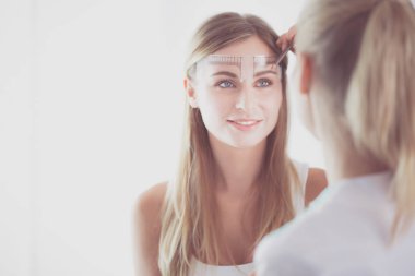 Kaşlar için kalıcı makyaj. Güzellik salonunda kalın kaşlı güzel bir kadın..