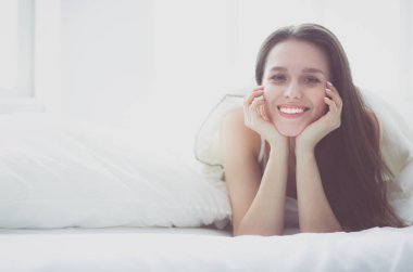 Güzel bir kadın yatağında uzanıyor..