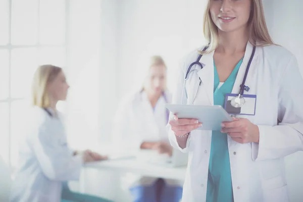 Retrato de una joven doctora, con almohadillas en la mano, en un consultorio médico — Foto de Stock