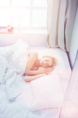 Güzel bir kadın yatağında uzanıyor.