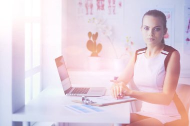 Kameraya gülümseyen steteskoplu arkadaş canlısı kadın doktorun portresi..