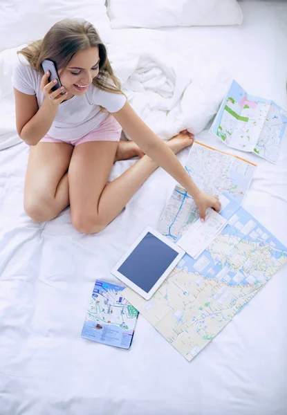 Entspannte junge Frau sitzt mit einer Tasse Kaffee und digitalem Tablet im Bett — Stockfoto