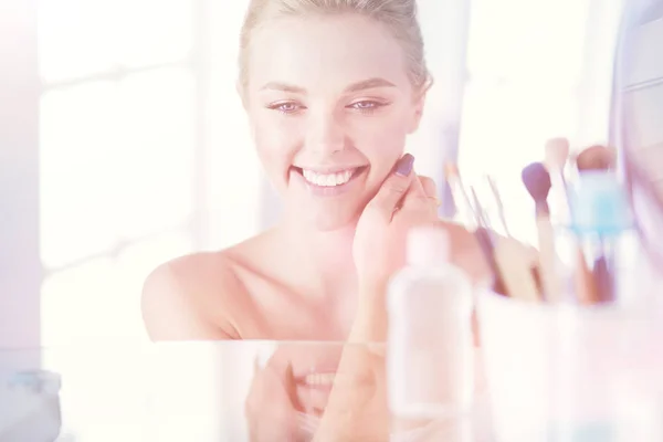 Young woman in bathrobe looking in bathroom mirror — Stock Photo, Image