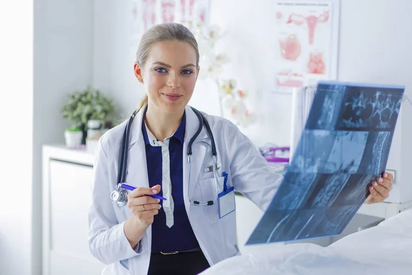 Giovane attraente medico femminile guardando l'immagine a raggi X — Foto Stock