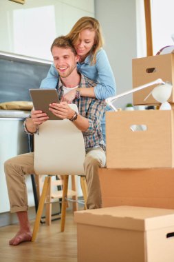 Genç bir çift yeni ev içinde hareket. Oturma ve açma sonra rahatlatıcı. Bir şey üstünde laptop arıyorum. Genç Çift