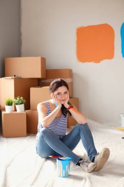 Mutlu gülümseyen kadın boya iç cephe yeni evin. Mutlu gülümseyen kadın