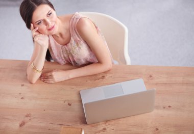 İş kadını ellerini başının arkasına koyup bir sandalyeye oturarak rahatlıyor. iş kadını