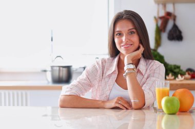 Mutfakta masada oturan genç bir kadın. Genç kadın.