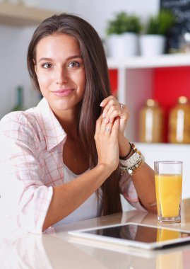 Mutfakta ipad 'ini kullanan genç bir kadın. Genç kadın.