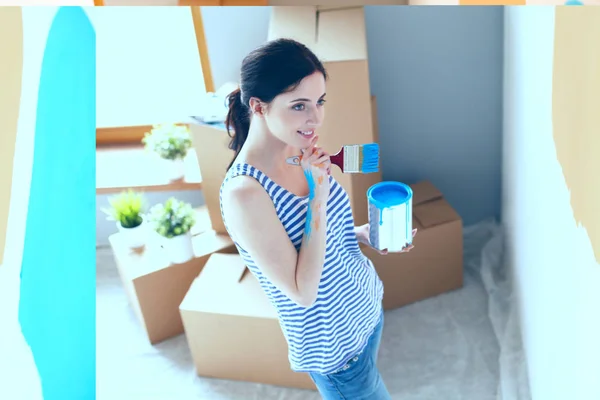 Gelukkig lachende vrouw schilderij interieur wand van nieuwe huis. Gelukkig lachende vrouw — Stockfoto