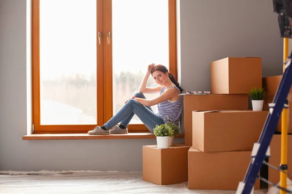 Femme dans une nouvelle maison avec des boîtes en carton. Femme dans la maison. — Photo