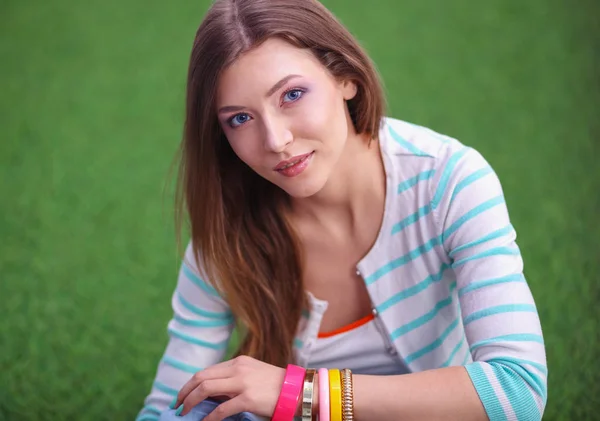 Una joven sentada sobre hierba verde. Portreit mujer joven — Foto de Stock