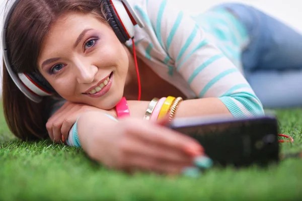 Hermosa mujer joven haciendo selfie por su teléfono mientras se encuentra en la hierba verde. Hermosa joven mujer haciendo selfie —  Fotos de Stock