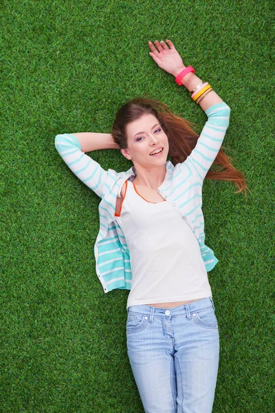 Hermosa mujer joven acostada en la hierba verde — Foto de Stock