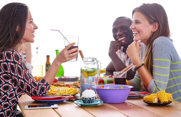 Vista superior do grupo de pessoas que jantam juntas enquanto estão sentadas à mesa de madeira. Comida na mesa. As pessoas comem fast food. — Fotografia de Stock