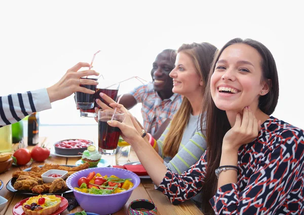 Pohled shora na skupinu lidí, kteří spolu večeří u dřevěného stolu. Jídlo na stole. Lidé jedí fast food. — Stock fotografie