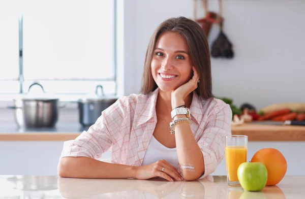 Young woman sitting a table in the kitchen. Young woman — Stock Photo, Image