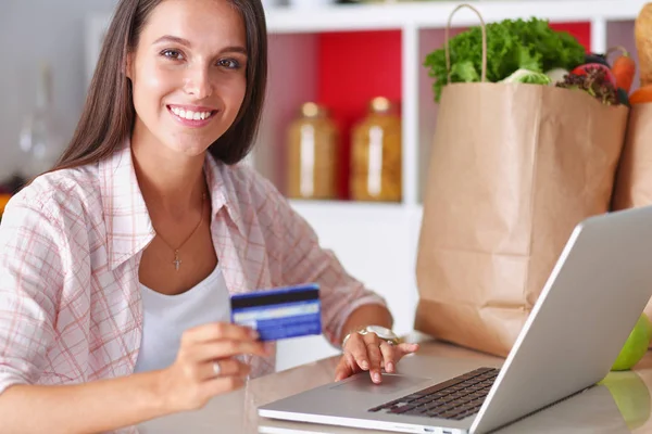Donna sorridente shopping online con tablet e carta di credito in cucina. Donna sorridente — Foto Stock