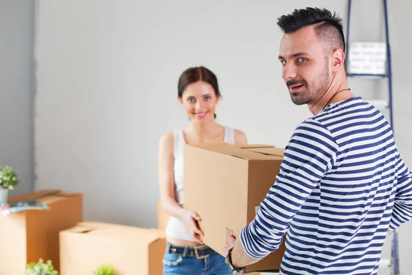 Glückliches junges Paar beim Auspacken oder Packen von Kartons und beim Einzug in ein neues Zuhause. junges Paar — Stockfoto