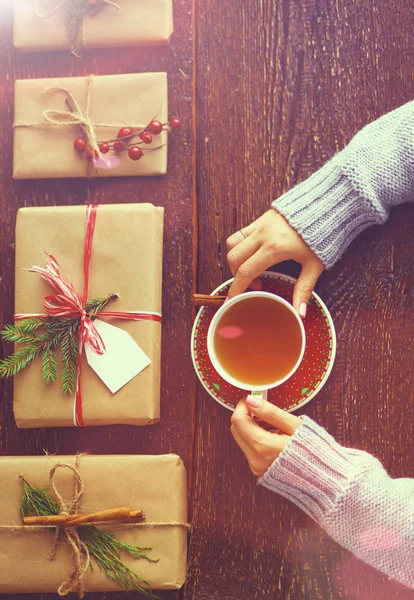 Femme assise sur le bureau avec boîte cadeau de Noël. Mains de femme — Photo